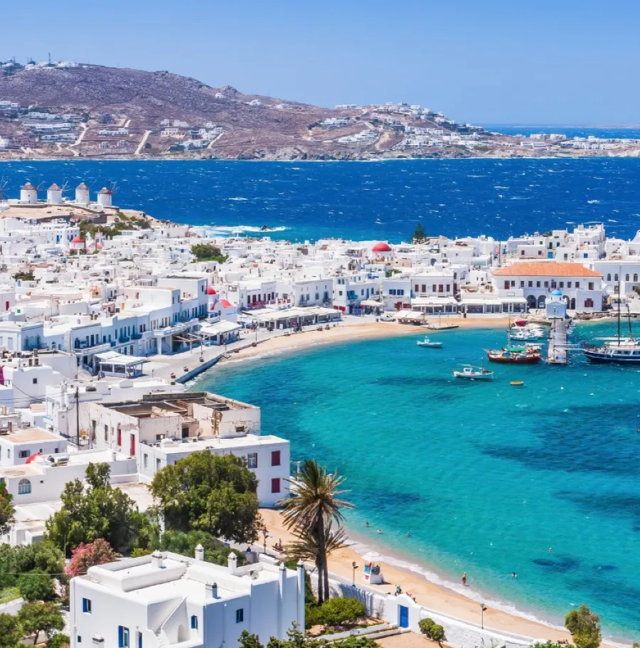 White houses above a turquoise bay on a Greek island