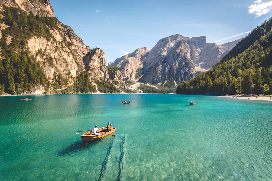 A boat on a turquoise alpine lake surrounded by mountains