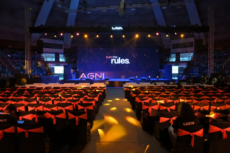 Rows of red seats facing the stage at the AGNI 3 launch