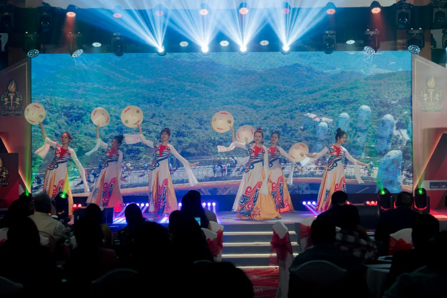 Dancers performing on a blue-lit stage at a gala night